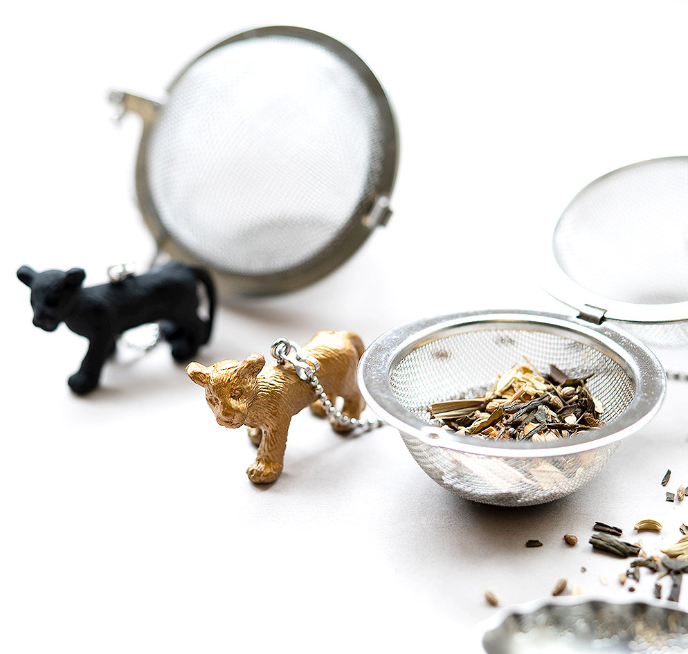 01Living Stainless steel Loose Leaf Tea Ball Infuser with Lion Charm, open and filled with loose-leaf tea before steeping.
