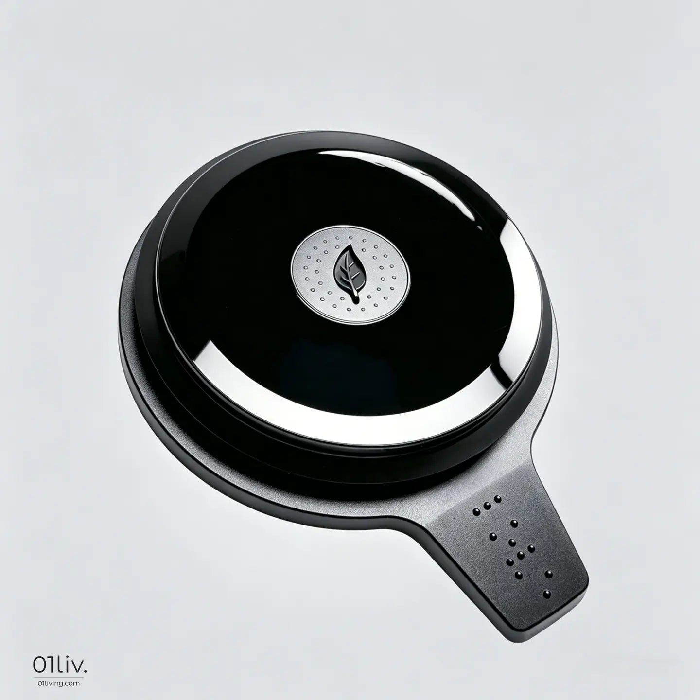 A sleek oval-shaped black tea pot lid with a glossy black base, a central leaf logo, and a ergonomic handle.