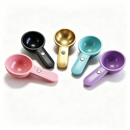 Perfect Magnetic Tea Scoop Set of 5 in assorted colours, black, gold, teal, pink, and purple, featuring integrated magnets for convenient attachment to tea canisters and consistent loose-leaf tea measuring. 
