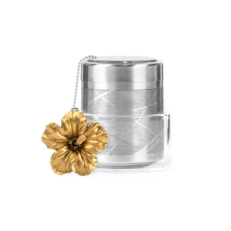 ChiChi Charm Loose Leaf Tea Infuser – Hibiscus Flower featuring a fine mesh stainless steel infuser, decorative hibiscus flower charm, patented U-Hook design, and glass drip bowl for brewing loose-leaf tea.